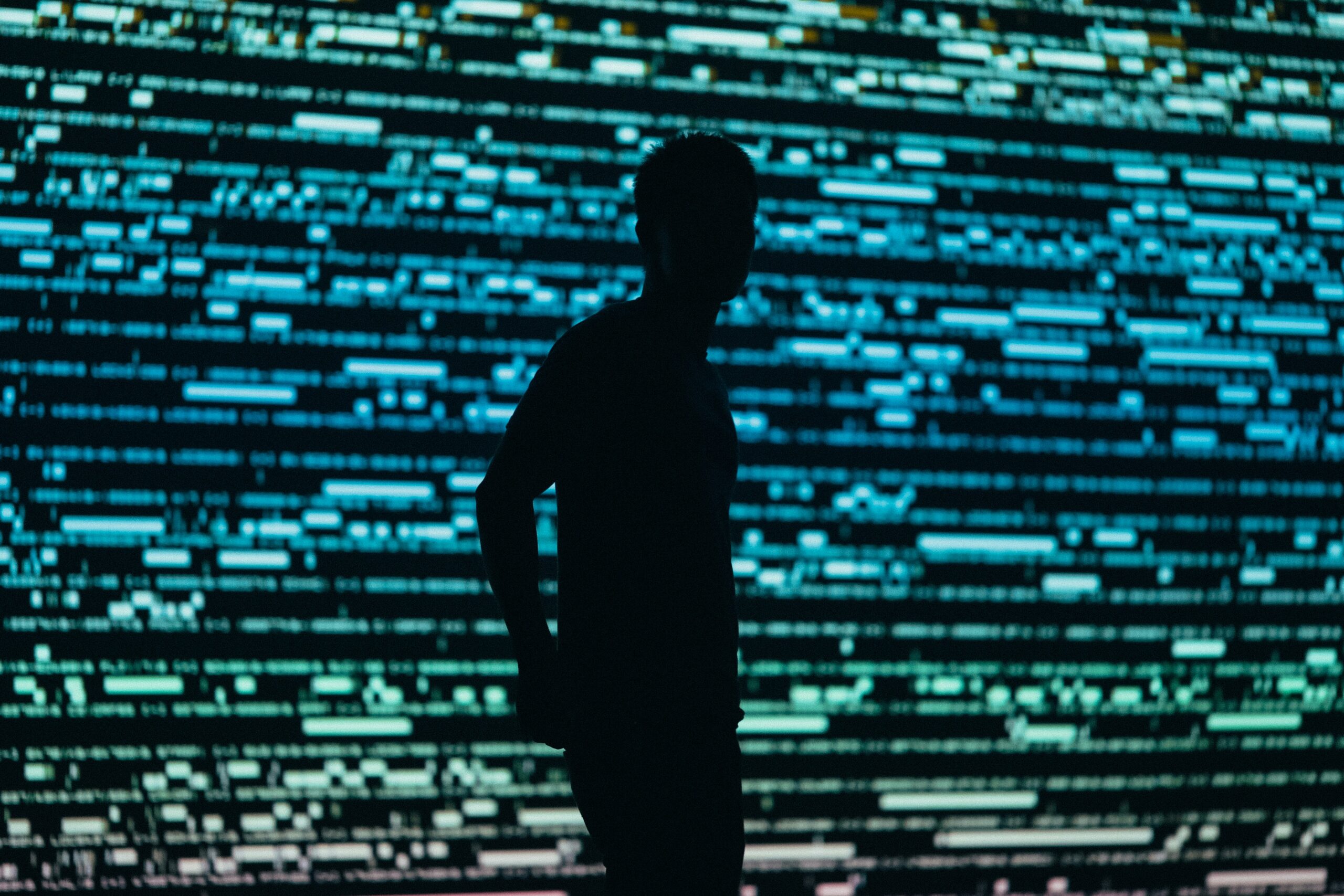 Silhouette of a man in front of a digital colour background.